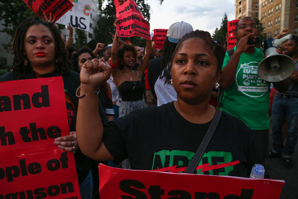A woman holds up her first during the march after National Moment of Silence for Michael Brown on Thursday, August 14, 2014 in Washington D.C. Protesters held a moment of silence for Michael Brown who was shot by police in Ferguson, Missouri. Brown was unarmed and had his hands up at the time he was shot. Photo credit: Brian Nguyen
