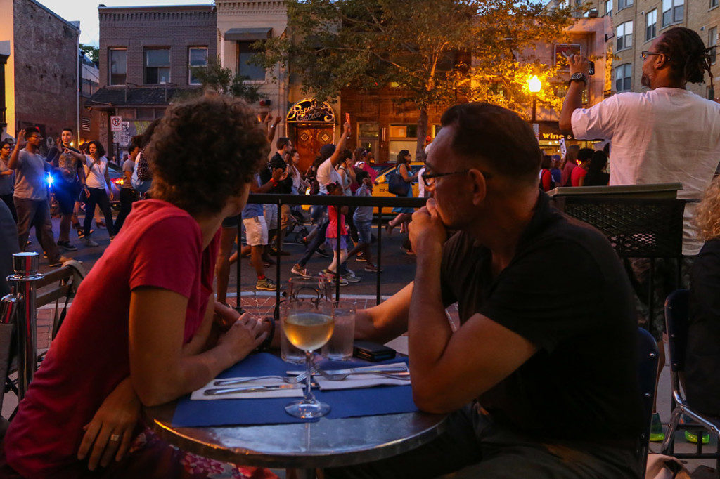 Diners observe the march as it made its way down U street after the National Moment of Silence for Michael Brown on Thursday, August 14, 2014 in Washington D.C. Protesters held a moment of silence for Michael Brown who was shot by police in Ferguson, Missouri. Brown was unarmed and had his hands up at the time he was shot. Photo credit: Brian Nguyen