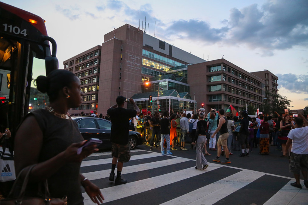 Passengers get off the bus after it was stopped by the march after the National Moment of Silence for Michael Brown on Thursday, August 14, 2014 in Washington D.C. Protesters held a moment of silence for Michael Brown who was shot by police in Ferguson, Missouri. Brown was unarmed and had his hands up at the time he was shot. Photo credit: Brian Nguyen