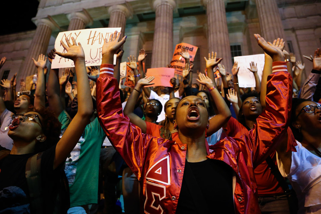The crowd holds up their hands after the march stopped across from the Verizon Center following the National Moment of Silence for Michael Brown on Thursday, August 14, 2014 in Washington D.C. Protesters held a moment of silence for Michael Brown who was shot by police in Ferguson, Missouri. Brown was unarmed and had his hands up at the time he was shot.  Photo credit: Brian Nguyen