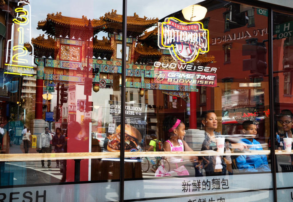 The gate to Chinatown is reflected on Fuddrucker's  windows on Tuesday, August 12, 2014. Washington DC's Chinatown has been increasingly gentrified as property costs rise and big chains move in. (Brian Nguyen/AAJA VOICES)